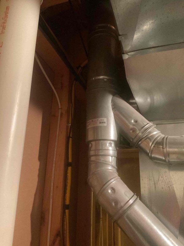 Provided estimate for water heater replacement in residential utility room. Assessed existing white cylindrical water heater installation with standard plumbing connections, copper piping, and PVC venting system. Documented current equipment condition, surrounding HVAC infrastructure including green furnace unit, and existing ductwork configuration to prepare comprehensive replacement proposal.