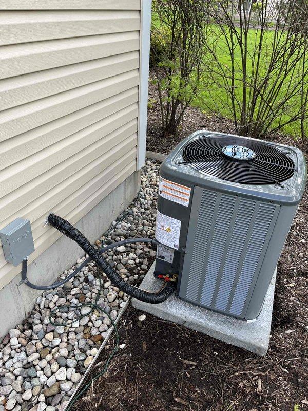 Completed full air conditioning system replacement at residential property. Installed new outdoor condenser unit on existing concrete pad with proper electrical disconnect and conduit routing through decorative stone bed, ensuring adequate clearance from structure. Interior installation included new air handler unit positioned adjacent to existing Bryant furnace in mechanical room, with all refrigerant lines, condensate drainage, and ductwork connections properly completed and tested for optimal system performance.