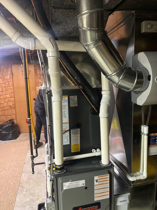 Successfully completed full furnace and air conditioning system installation in residential basement. Installed Amana furnace unit with proper condensate drain lines and PVC venting, connected metallic ductwork, and integrated AC system components. All equipment mounted on protective mat, secured with appropriate brackets and supports, with organized routing of utilities per standard HVAC installation practices.