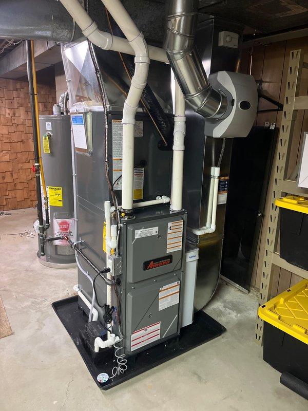 Successfully completed full furnace and air conditioning system installation in residential basement. Installed Amana furnace unit with proper condensate drain lines and PVC venting, connected metallic ductwork, and integrated AC system components. All equipment mounted on protective mat, secured with appropriate brackets and supports, with organized routing of utilities per standard HVAC installation practices.