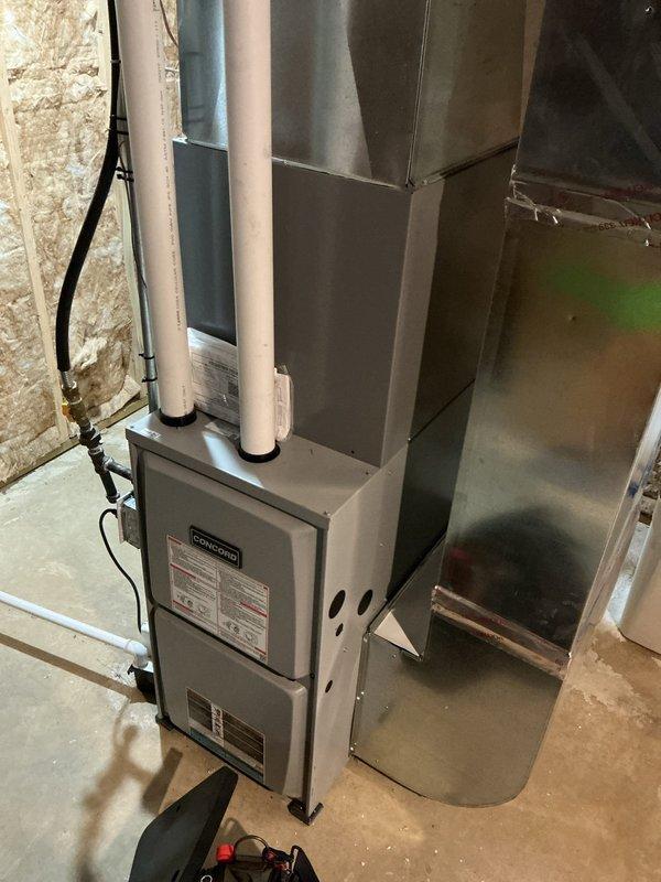 Responded to service call for Bradford White water heater reported as not heating consistently. Upon arrival, found unit to be an Infiniti tankless water heater approximately 5 years old, not the tank-type Bradford White initially reported. Inspected unit displaying temperature reading of 82°F on digital control panel. Evaluated all plumbing connections, venting system including white PVC exhaust pipes, copper water lines, and electrical connections for proper operation. Documented installation with photos showing complete system setup including ductwork and HVAC components in utility area. System assessed and customer advised of findings regarding inconsistent heating performance.