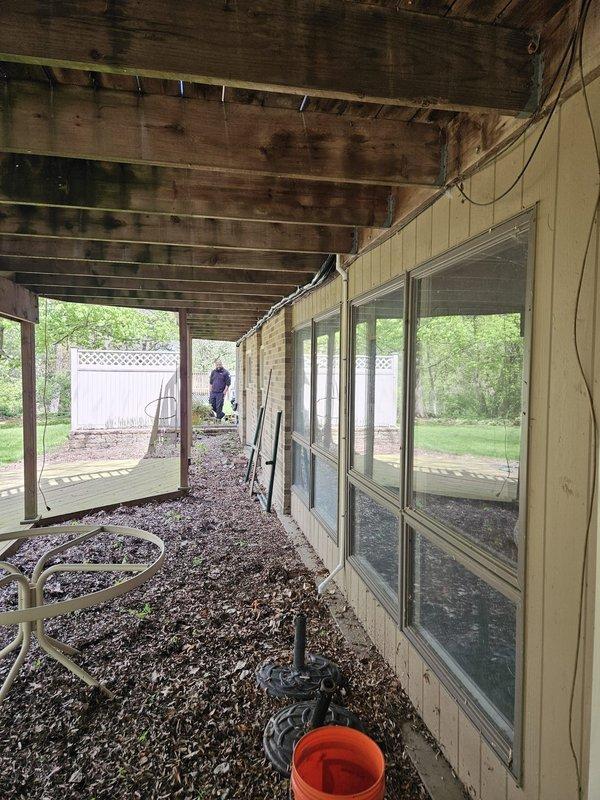 Completed installation of ductless mini-split system in residential sunroom with covered porch area. Mounted indoor air handler unit on interior wall above window bank, established refrigerant line connections to outdoor condenser unit, and ran electrical supply and control wiring through exterior wall penetrations. System tested and verified operational with proper cooling capacity and airflow distribution throughout the space.