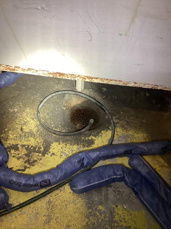 Responded to recurring backup and slow drainage issue caused by root intrusion in aging tile and cast iron main sewer line running from structure to curb. Customer reported ongoing problems over a two-year period. Accessed floor drain in utility area and performed thorough camera inspection of main line to identify extent of root penetration and structural condition of deteriorated piping. Documented findings with photographic evidence showing access points and existing plumbing infrastructure including corroded copper supply lines and concrete utility basin in basement workspace. Recommended main line replacement or trenchless rehabilitation due to compromised integrity of original tile/cast iron system and persistent root infiltration beyond effective mechanical cleaning solutions.