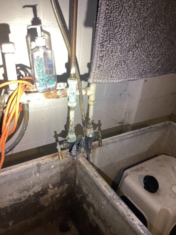 Responded to recurring backup and slow drainage issue caused by root intrusion in aging tile and cast iron main sewer line running from structure to curb. Customer reported ongoing problems over a two-year period. Accessed floor drain in utility area and performed thorough camera inspection of main line to identify extent of root penetration and structural condition of deteriorated piping. Documented findings with photographic evidence showing access points and existing plumbing infrastructure including corroded copper supply lines and concrete utility basin in basement workspace. Recommended main line replacement or trenchless rehabilitation due to compromised integrity of original tile/cast iron system and persistent root infiltration beyond effective mechanical cleaning solutions.