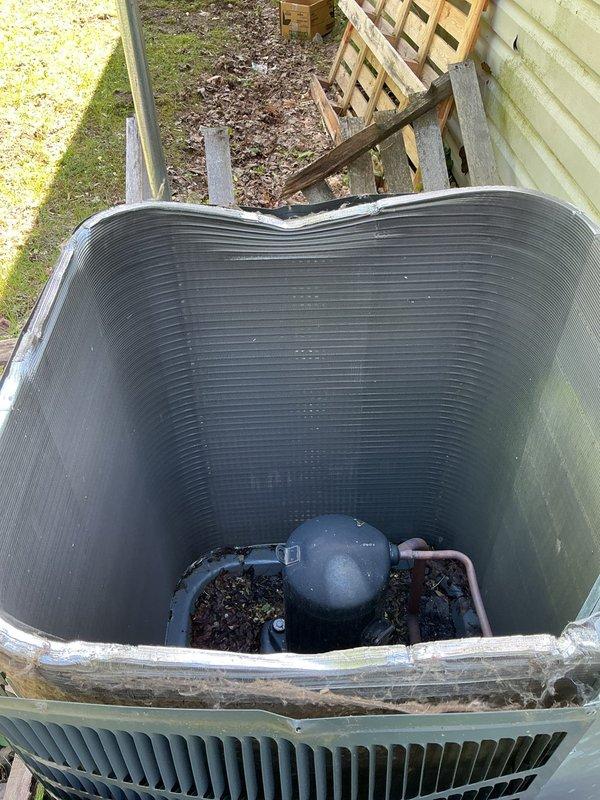 Responded to no cooling complaint on 4-year-old Goodman system with condenser unit not running. Upon arrival, found condenser fan motor failed and debris accumulation in outdoor unit restricting airflow. Removed leaves and organic material from condenser cabinet, tested electrical components, and confirmed fan motor failure. Replaced condenser fan motor, cleared all debris from unit, verified proper amperage draw and capacitor operation. System restored to normal cooling operation with proper airflow and refrigerant pressures. Enrolled customer in annual maintenance program and collected voided check for automatic payment setup as requested.