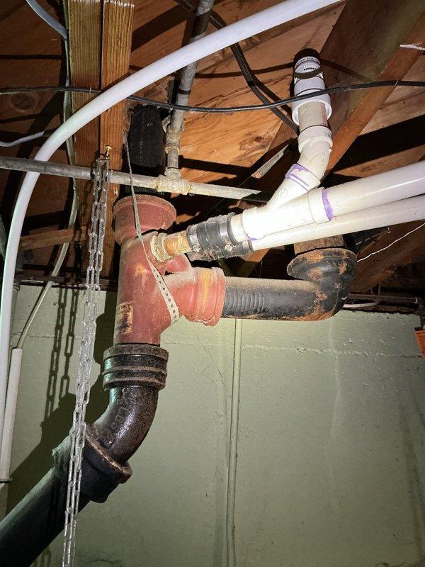 Responded to slow-draining bathroom sink issue. Inspected P-trap assembly and drainage system beneath fixture, finding chrome-plated trap and tailpiece connections in serviceable condition. Examined exposed drain lines in basement crawl space, documenting existing cast iron and PVC piping configuration to verify proper drainage slope and identify potential blockage points. Cleared obstruction and restored proper drainage flow to fixture.