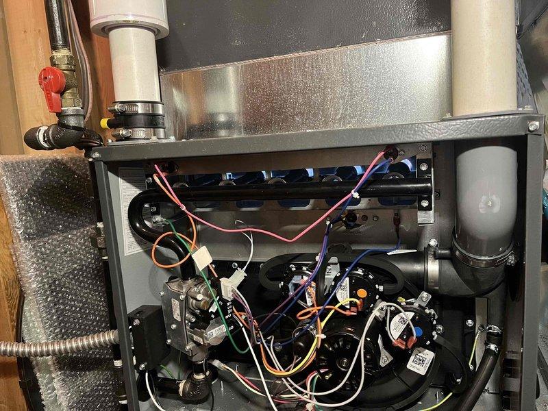 Completed annual heating and cooling tune-up on 2011 HVAC system with furnace, air conditioning, and humidifier components. Performed comprehensive inspection of air handler unit, including examination of heat exchanger for condensation and proper operation, verified all electrical connections and control board functionality, and inspected gas line connections and safety controls. Checked blower motor assembly, capacitor, and associated wiring for proper operation. Evaluated air filtration system and confirmed proper airflow through mesh filter assembly. Inspected humidifier unit and associated water connections, including PVC piping and shut-off valve. All components found operating within normal parameters with no immediate service needs identified. System covered under extended warranty through August 2032.