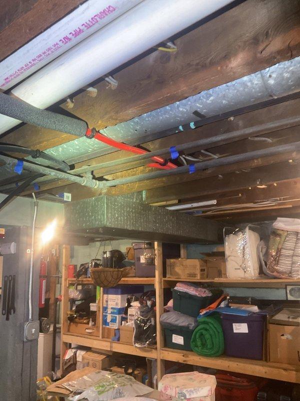 Completed installation of 40-gallon natural gas water heater with 6-year warranty and short configuration in basement utility area. Unit was installed per manufacturer specifications with proper venting, gas line connections, and code-compliant clearances in existing mechanical space alongside other utility systems.