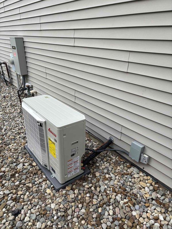 Completed full HVAC system installation including new furnace and Amana air conditioning condenser unit. Unit was properly mounted on composite pad with river rock landscaping base, electrical disconnect box installed per code, and all refrigerant lines and conduits secured to building exterior. System tested and operational upon completion.