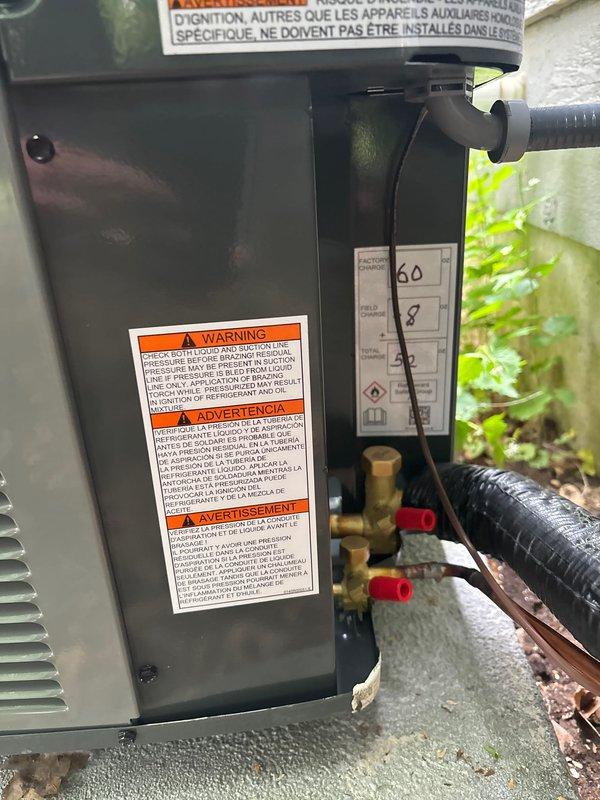 Completed full air conditioning system replacement at residential property. Installed new outdoor condensing unit with proper refrigerant line connections, electrical hookup, and mounting on concrete pad. System tested and verified operational, with all safety labels and manufacturer specifications properly displayed on equipment.