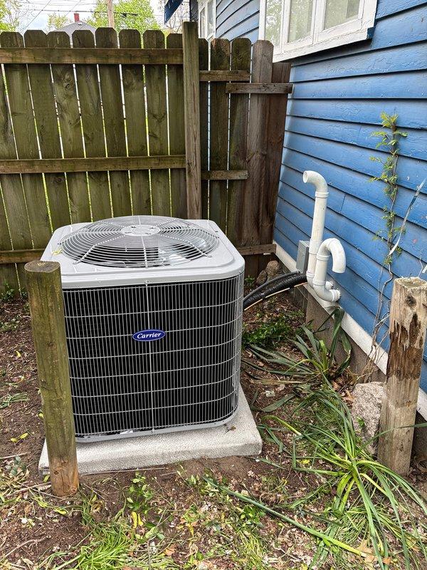 Completed full HVAC system installation including Carrier condensing unit positioned on concrete pad in side yard with proper clearances, new residential tank-style water heater installed in basement mechanical room with copper supply lines and expansion tank, and furnace installation as part of complete system replacement. All units connected per manufacturer specifications with appropriate electrical, gas, and plumbing connections, system tested and verified operational.