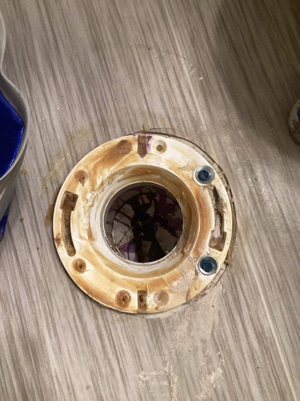 Responded to toilet stability issue in lower bathroom where fixture was loose on one side. Upon inspection, found deteriorated toilet flange with corrosion and wear on mounting hardware. Secured toilet by tightening existing bolts and replacing corroded fasteners with new hardware and washers to ensure proper seal and stability.