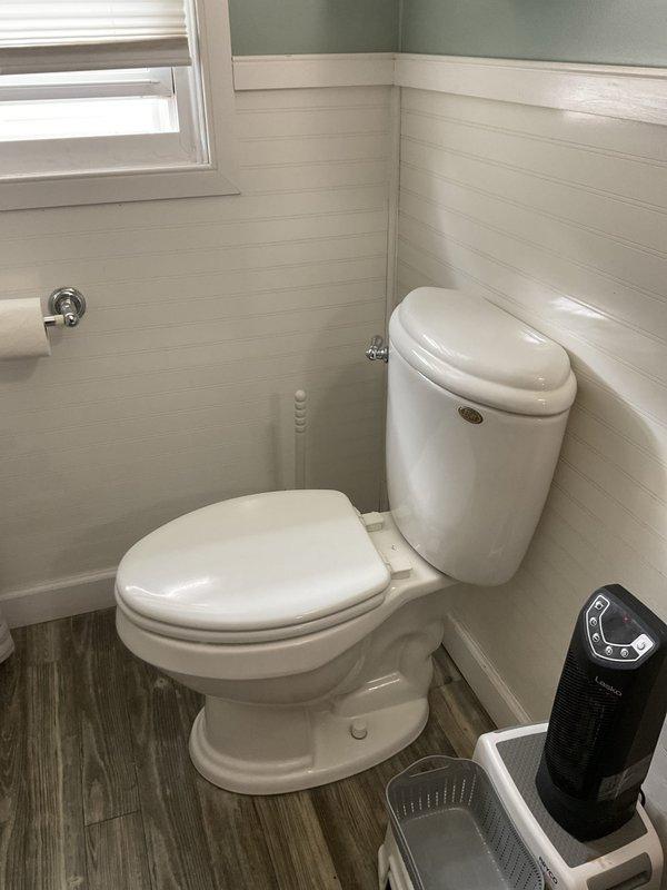 Responded to service call for non-flushing toilet. Upon arrival, inspected two-piece toilet in bathroom with shiplap paneling and identified flush mechanism malfunction. Successfully repaired flush valve assembly, restoring proper flushing operation to the unit.
