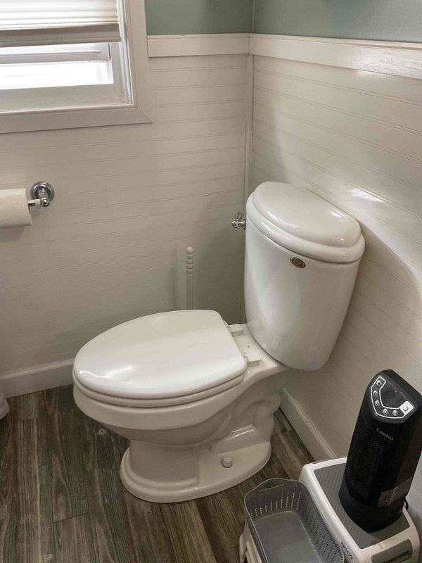 Responded to service call for non-flushing toilet. Upon arrival, inspected two-piece toilet in bathroom with shiplap paneling and identified flush mechanism malfunction. Successfully repaired flush valve assembly, restoring proper flushing operation to the unit.