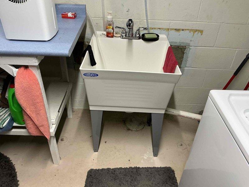 Completed inspector-required corrections including securing laundry sink to floor with appropriate anchoring hardware and installing proper grounding connection to water heater per code requirements. Verified all plumbing fixtures stable and electrical grounding properly bonded to ensure compliance with inspection standards.