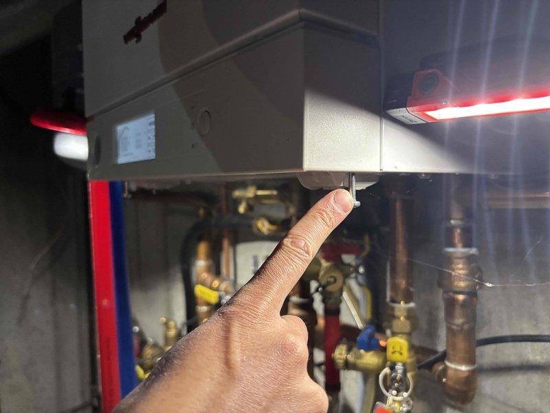Responded to service call for boiler not reaching set temperature on 10-year-old system. Upon inspection, identified control unit malfunction preventing proper temperature regulation. Examined wall-mounted heating control with digital display and associated valve manifold system including multiple brass fittings with colored handles. Assessed copper piping connections and electrical junction boxes showing signs of age and patina buildup. Verified proper electrical connections at terminal points and evaluated overall system operation to restore heating functionality to programmed temperature settings.