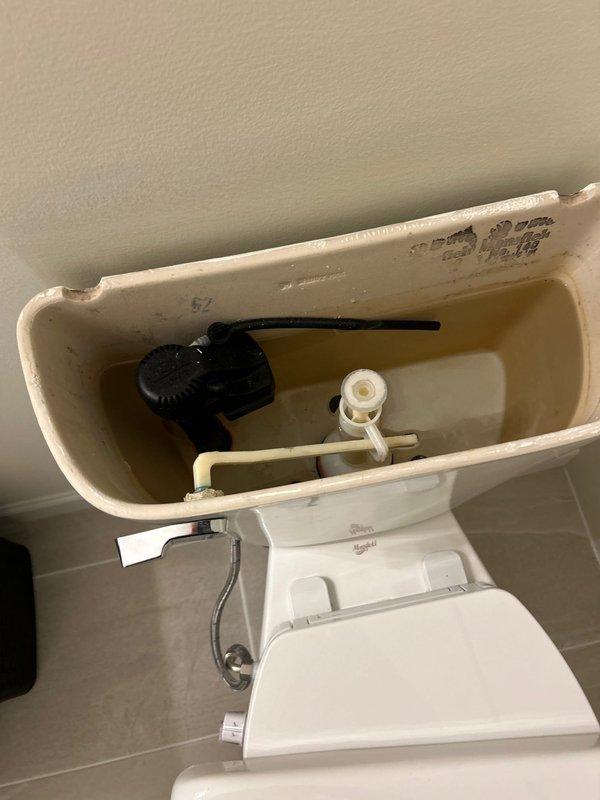Responded to service call for toilet not flushing correctly. Upon inspection, removed tank lid and examined internal flush mechanism components including flush valve assembly and fill valve system. Documented existing conditions of toilet tank interior and surrounding bathroom area. Water supply line and wall valve connection verified as secure and functioning properly.