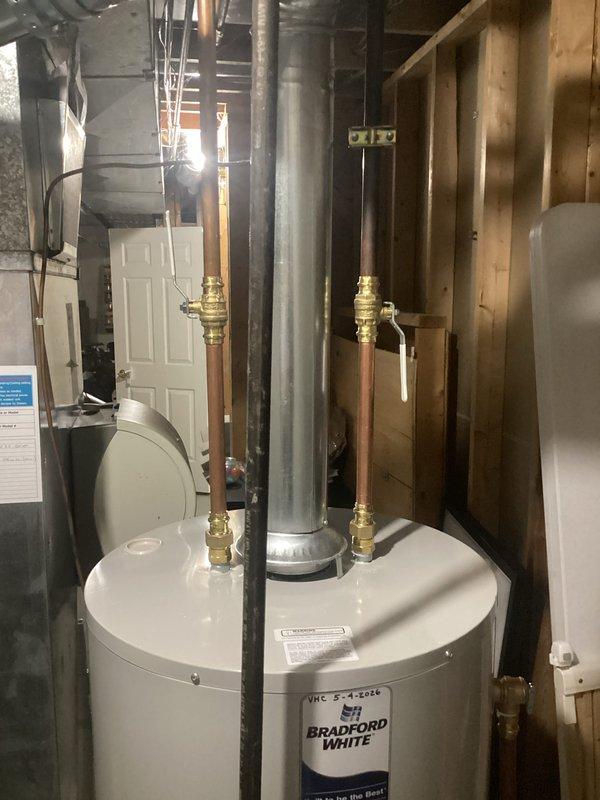 Completed installation of a 40-gallon natural gas Bradford White water heater in basement utility area. Installed unit with proper copper piping connections, brass pressure relief valves, and appropriate venting through existing ductwork. Configured condensate drain system using PVC piping with proper fittings and connections to floor drain. Verified all connections for proper sealing, tested pressure relief mechanisms, and ensured compliance with residential plumbing code requirements for hot water heating systems.