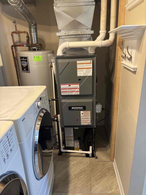 Completed full HVAC system installation including new furnace and air conditioning unit. Interior furnace installed in utility room with proper PVC venting and ductwork connections. Exterior condensing unit positioned on concrete pad with refrigerant lines, electrical disconnect, and condensate drain line properly installed through exterior wall. All equipment tested and verified operational upon completion.