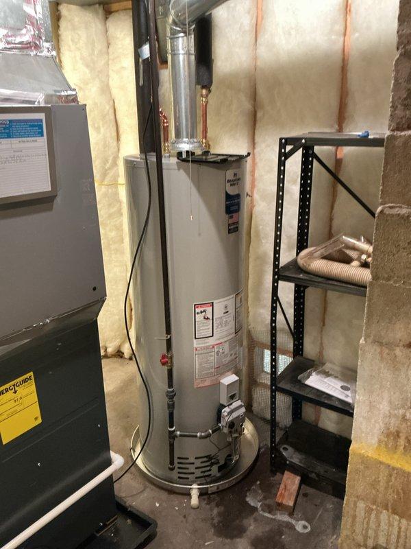 Completed installation of a 40-gallon natural gas water heater (tall model, 10-year tank/10-year parts warranty) in basement utility area. Established all plumbing connections using copper piping with brass compression fittings, installed proper venting through metallic ductwork, and verified all gas line connections for safe operation. Unit tested and operational upon completion.