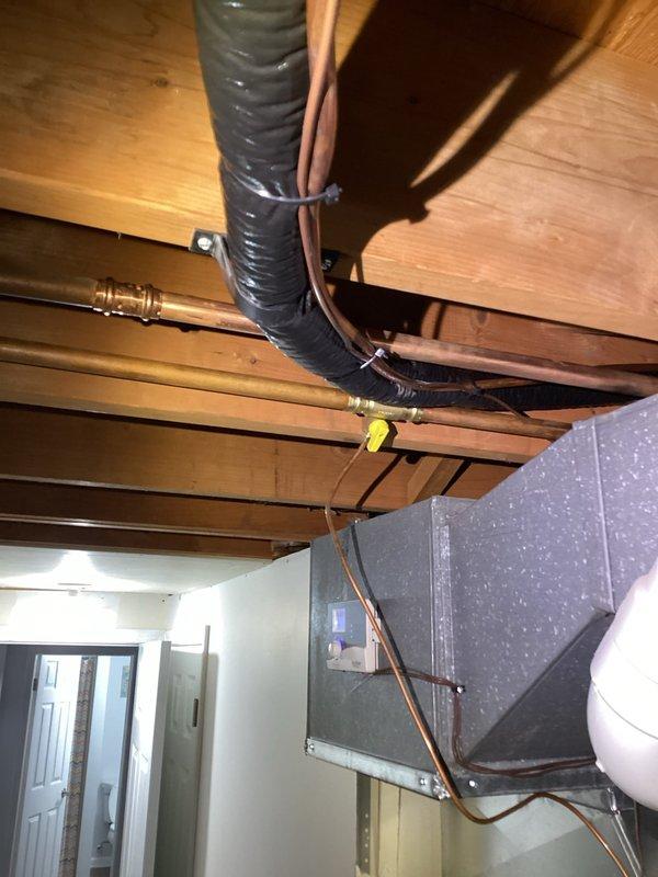 Completed water heater repair in residential utility room. Serviced plumbing connections, inspected copper supply lines, brass valves, and associated piping system to restore proper operation. All components tested and functioning correctly upon completion.