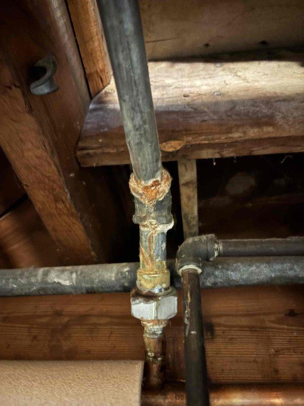 # AC Annual Cooling Maintenance - Lennox System

Completed annual cooling maintenance on a 2016 Lennox air conditioning unit with 22 years of service history. Performed comprehensive system inspection including refrigerant levels, electrical connections, condensate drain operation, and overall unit performance. 

During inspection, documented existing plumbing infrastructure conditions in the vicinity of the HVAC system. Observed galvanized steel piping with visible corrosion, rust deposits at threaded connections, and mineral buildup at pipe joints. Noted aging pipe fittings showing oxidation and deterioration that may require future attention from a licensed plumber.

System operational testing confirmed air conditioning unit is functioning within normal parameters. All safety controls verified operational. Photographic documentation captured for maintenance records.