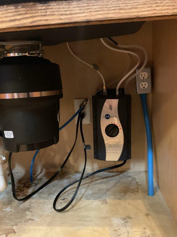 Installed customer-supplied instant hot water dispenser system under kitchen sink, including mounting the InSinkErator heating tank unit and connecting associated electrical and plumbing components. Completed installation with functional testing to verify proper operation of the hot water dispenser and faucet assembly.