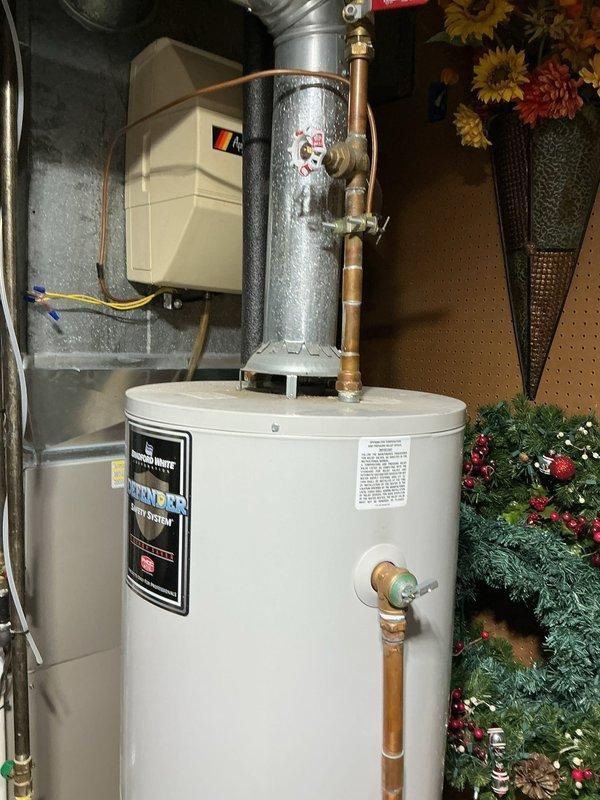 Responded to emergency water heater leak with active flooding in basement utility area. Upon arrival, confirmed water and electrical power had been safely shut off to the 16-year-old Bradford White unit. Assessed the extent of water damage to surrounding floor area and documented conditions with photographs. The water heater, which had been functioning normally prior to the leak, showed signs of tank failure consistent with its age beyond typical service life expectancy. Verified all utilities remained secured and area was safe, preventing further water damage to the space and stored items.