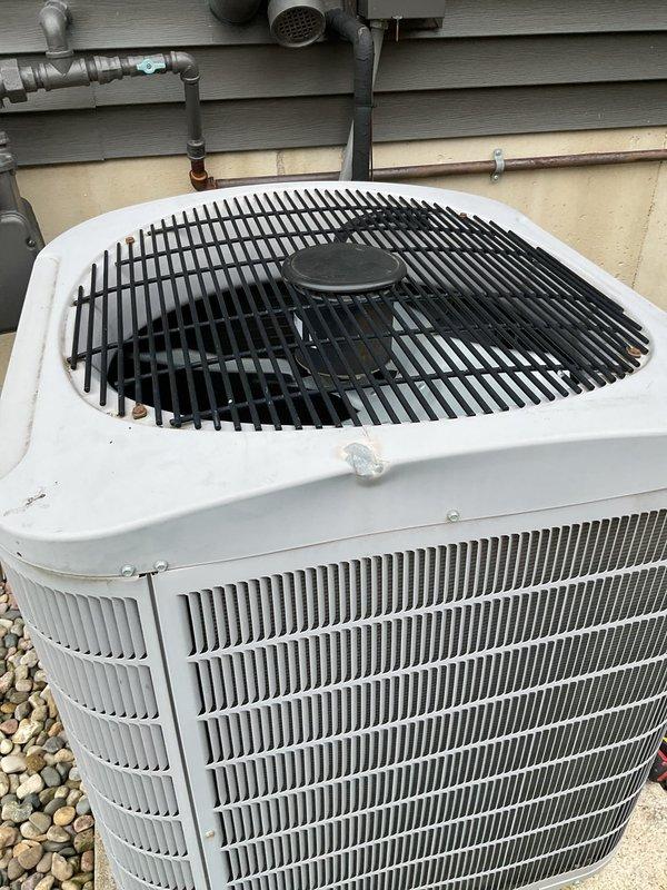 Completed comprehensive ASTU-AC Super Tune-up on outdoor condensing unit with white casing and rounded square design. Upon arrival, customer was uncertain about current cooling performance and system age, though motor had been replaced within recent years. Performed full system inspection and diagnostics, including electrical testing, refrigerant level verification, and operational assessment of compressor and fan motor. Cleaned condenser coils which showed significant dust accumulation and outdoor weathering on horizontal fins. Verified proper function of all electrical connections and controls. Inspected refrigerant lines, insulation, and disconnect box mounted on exterior wall. Tested system startup and shutdown sequences, confirmed adequate airflow through black protective fan grille, and verified proper heat exchange operation. System restored to optimal operating condition. Additionally provided estimate for new AC pad installation as requested by customer.