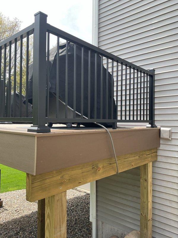 Completed gas line installation and routing for residential deck structure. Installed and secured new gas piping along deck fascia and through underside of covered porch area, utilizing pressure-treated lumber support system for proper mounting. Employed ratchet straps for temporary stabilization during installation process. Routed gas line in compliance with code requirements, ensuring proper clearances from electrical conduit and maintaining secure attachment points to structural beams. All connections tested and verified for safe operation.