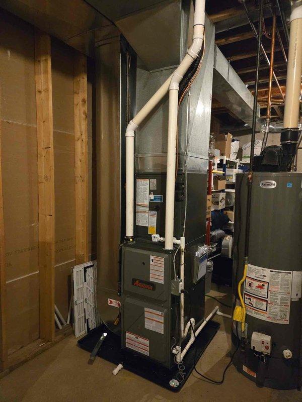 Successfully completed full HVAC system installation including new Amana furnace and outdoor air conditioning condenser unit. Installed furnace in basement utility area with proper PVC venting routed through ceiling joists to exterior. Mounted outdoor AC condenser on concrete pad with appropriate electrical disconnect and conduit installation on exterior wall. Connected refrigerant lines between indoor and outdoor units, completed all electrical connections per manufacturer specifications, and verified proper drainage routing. System tested and confirmed operational with all safety controls functioning correctly.