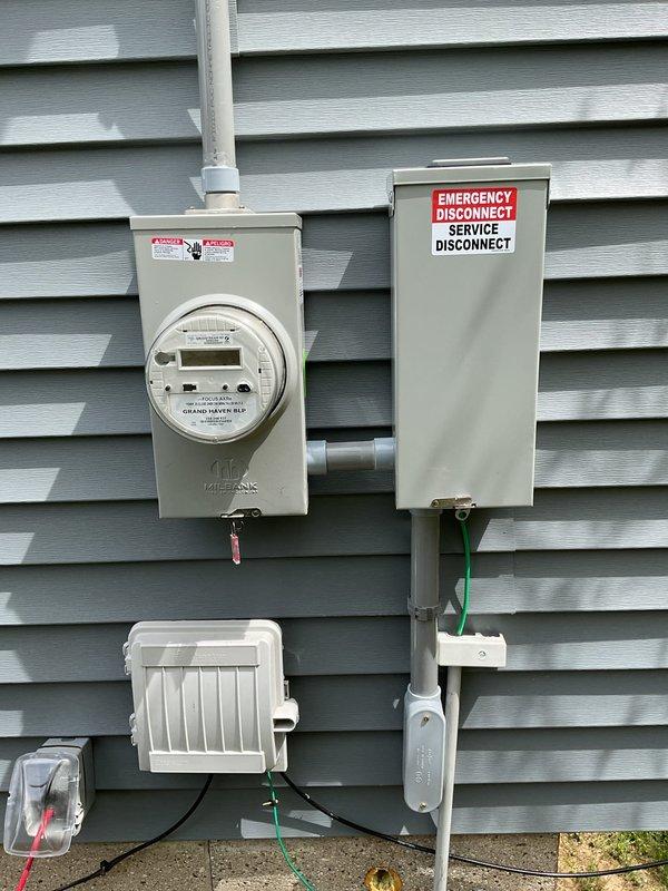 Completed electrical service upgrade under permit PE260062 with coordination through Grand Haven Power and Light for temporary disconnect and reconnect. Installed new electrical meter, emergency disconnect box, and upgraded interior electrical panel with proper conduit routing. Work included mounting exterior service equipment on building siding with PVC conduit connections, installing recessed interior panel box with ceiling wire entry, and completing all necessary rough-in work around panel installation. Scheduled and passed required electrical inspection, with power restoration completed same day following inspector approval.