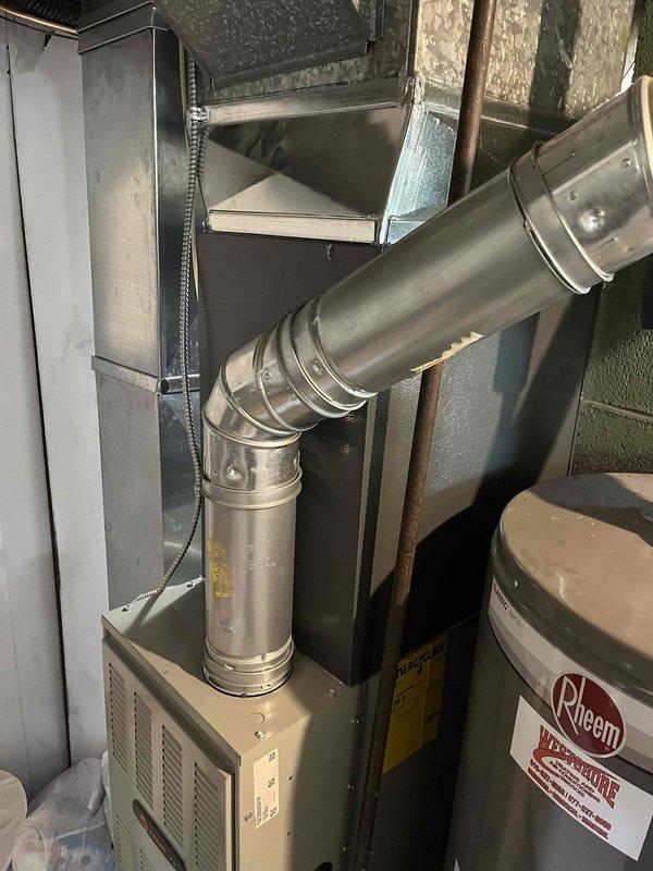 Completed add-on air conditioning installation to existing forced-air heating system in basement utility area. Installed new air handler unit with associated ductwork connections, including flexible supply duct routing and metal plenum integration with existing furnace system. Configured condensate drain lines using PVC piping, established electrical connections and control wiring between new AC components and existing HVAC equipment, and secured all documentation and system specifications on-site for future reference.