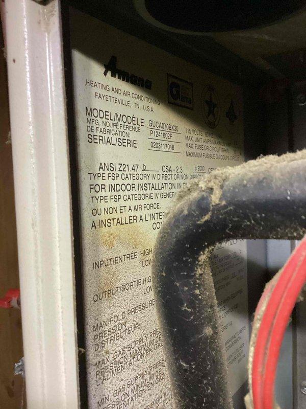Responded to no-heat service call for 15-year-old Goodman GUCA070AX furnace system. Customer reported "no wires detected" error on smart thermostat upon returning from vacation. Customer had already replaced thermostat, but system continued to only blow air without heating. 

Upon inspection, examined furnace control board wiring and thermostat connections. Photographed internal compartment showing draft inducer motor, control modules, and low-voltage wiring configuration. Noted visible rust and corrosion on furnace base plate beneath blower assembly, indicating potential moisture intrusion issues. Verified manufacturer specifications on unit data plate showing Type FSP Category IV indoor installation requirements.

Diagnosed thermostat wiring issue at furnace control board. Traced low-voltage wiring connections including R, C, W, G, and Y terminals. Identified compromised wire connections or failed control board preventing proper communication between thermostat and heating system. Co