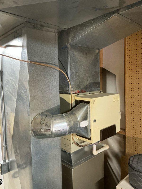 Conducted sales estimate for residential air conditioning system at property with existing forced-air HVAC installation in basement utility area. Evaluated current furnace unit with metal ductwork distribution system, copper refrigerant lines, and PVC condensate drain configuration. Documented existing equipment layout including sheet metal duct assembly, cylindrical duct components, and humidifier units to provide customer with accurate quote options for AC system integration with operational heating equipment.