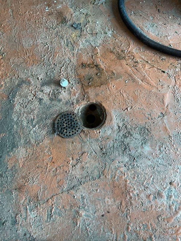 Responded to garage floor drain backup occurring when showers were running. Removed drain cover, cleared obstruction from drain line, and restored proper drainage flow. Tested system to confirm water now draining properly without backup issues.