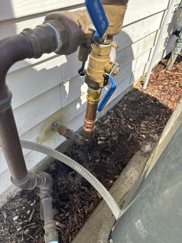 Responded to plumbing leak emergency involving broken pipe on backflow prevention system. Located and accessed exterior shut-off valve at foundation level as directed. Replaced damaged section of copper piping connected to brass ball valve assembly with blue handle. Verified proper operation of backflow preventer and associated brass fittings, ensuring all connections were secure and leak-free. System tested and restored to full operational status.