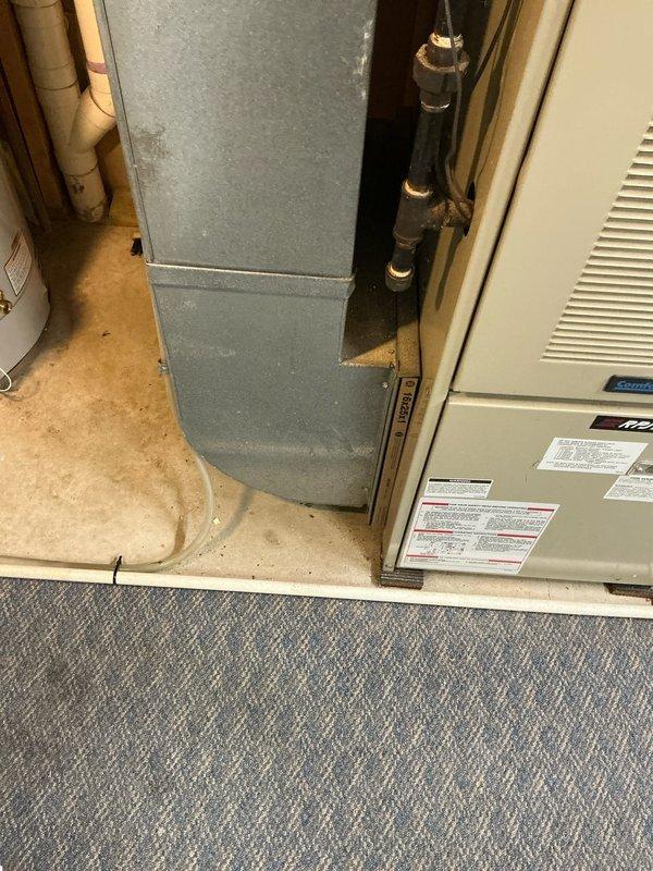 Conducted sales estimate for replacement of 30-year-old residential forced air furnace system currently operational in utility closet. Documented existing beige furnace unit with galvanized metal ductwork, adjacent water heater, and overall mechanical room configuration through photographic assessment to provide comprehensive replacement proposal for aging HVAC equipment.