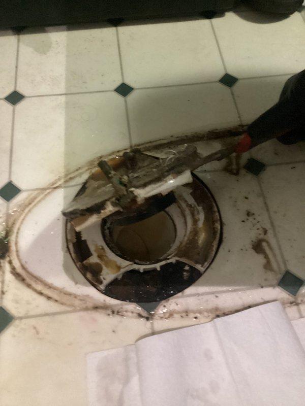 Responded to customer report of water leaking from the base of the toilet onto the floor after flushing. Upon arrival, removed toilet from floor flange to inspect the seal and mounting hardware. Found heavily corroded and rusted toilet flange with deteriorated wax ring seal, which was the source of the leak. The flange exhibited significant oxidation and the surrounding floor area showed evidence of water damage and staining from prolonged moisture exposure. Removed old wax ring and cleaned the flange area of debris and residue. Replaced the defective wax ring with new seal and reinstalled toilet, ensuring proper alignment with flange and secure mounting to prevent future leaks.
