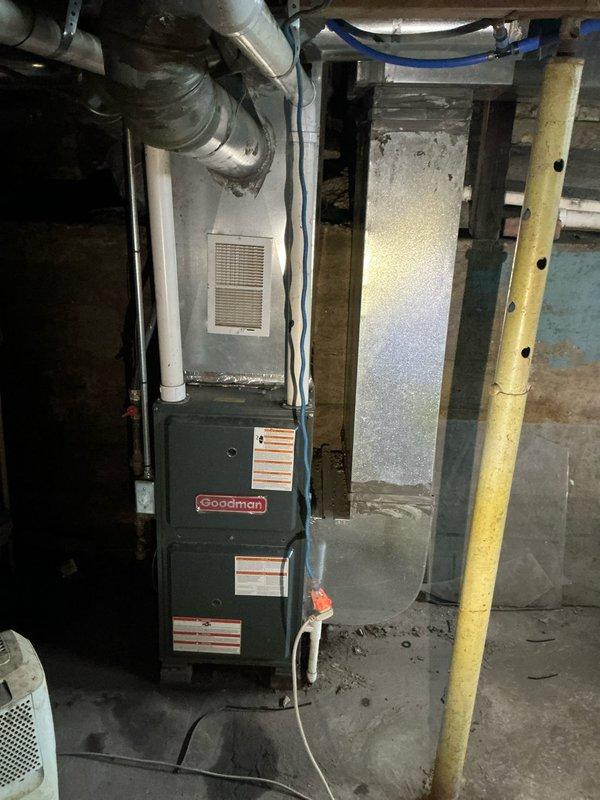 Responded to flooded basement emergency requiring assessment and estimate for complete HVAC and water heater replacement. Documented existing Goodman furnace unit, water heater, and associated mechanical systems that sustained water damage from submersion. Photographed damaged equipment including furnace with exposed ductwork, PVC venting, electrical connections, and water heater with PEX plumbing configuration to support replacement estimate for insurance purposes.