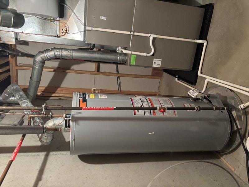 Completed annual heating and cooling maintenance visit on residential HVAC system. Performed comprehensive tune-up on furnace, humidifier, and Carrier air conditioning condenser unit. Inspected indoor air handler cabinet, ductwork connections, and all associated piping systems including copper and PVC lines. Verified proper operation of water heater connections and safety controls. Examined outdoor condenser unit including fan operation, coil condition, and electrical disconnect box. All components found to be in good working condition with no issues identified. System operating within normal parameters. Documentation photos captured for service records.