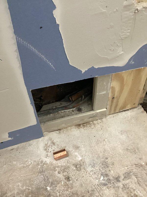 Brazed suction line repair on HVAC system and recharged unit with 2 tons of R22 refrigerant. Wall access was required to complete the repair, with opening created to reach the damaged suction line section for proper brazing and system restoration.