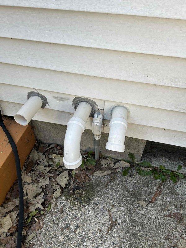 Responded to water leak complaint on 1-year-old Bradford White WT 11-2030 water heater with water discharging from plastic tubing. Upon inspection, identified leak originating from temperature and pressure relief valve discharge pipe. Inspected exterior PVC drainage system and confirmed proper installation of discharge piping through building exterior with appropriate mounting brackets. Verified water heater installation in basement utility room, examined copper supply lines, gas connections with yellow shut-off valve, and overall unit condition. Documented leak source and plumbing configuration for warranty consideration given unit age.