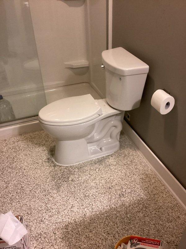 Responded to downstairs bathroom odor complaint with suspected toilet venting issue. Conducted inspection of toilet installation and surrounding plumbing system. Created access panel in drywall adjacent to toilet to assess drain and vent pipe condition for potential leaks. Inspected exposed framing and plumbing connections behind wall cavity. Documented conditions with photographs showing access point and bathroom fixtures. Issue reported as improved by occupant; further evaluation of venting system may be required pending findings from wall cavity inspection.