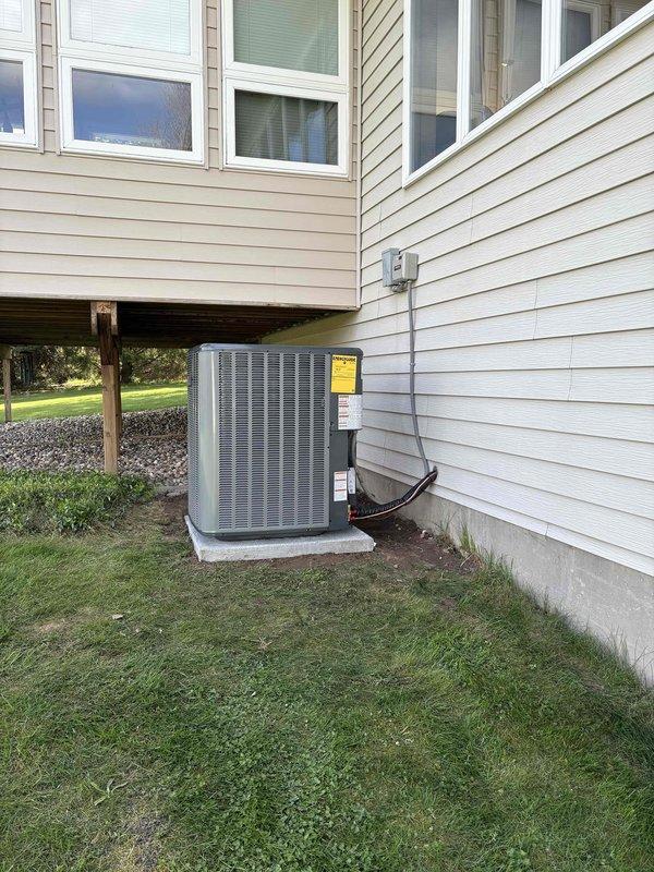 Successfully completed full air conditioning system installation at residential property. Installed new outdoor condensing unit on concrete pad with proper electrical connections and refrigerant lines running to indoor air handler. Connected system to existing furnace and ductwork in basement, verified all PVC condensate drain lines and venting are functioning properly, tested system operation, and confirmed proper airflow and cooling performance throughout the home.