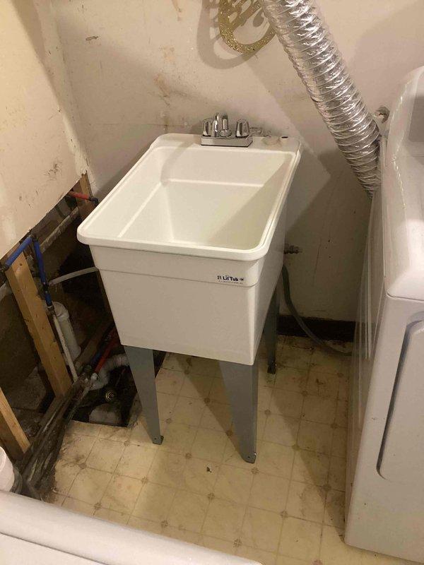 Installed client-supplied utility sink in basement utility room, including mounting basin on metal leg frame, connecting chrome dual-handle faucet, and completing all necessary plumbing connections to existing water supply lines and drain system. All connections tested and verified leak-free upon completion.