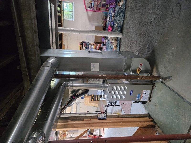 Successfully completed full HVAC system replacement in basement location, installing new Carrier brand furnace and air conditioning system. Removed existing equipment and installed modern high-efficiency units with complete ductwork integration, including new metallic supply and return ducts with proper transitions and elbows throughout the space. Configured air handler unit with vertical mounting in metal frame structure, connected all ductwork sections with proper sealing, and ensured proper clearances from structural elements and concrete walls. Verified all electrical connections, tested system operation for heating and cooling functions, and confirmed proper airflow throughout the distribution system. All installation work completed to manufacturer specifications and local code requirements, with system fully operational and ready for service.