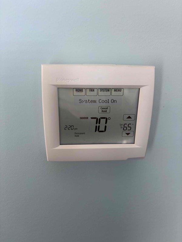 Completed annual cooling maintenance on 11-year-old ICP air conditioning system. Performed comprehensive tune-up including system inspection, verified thermostat operation showing system cooling properly with indoor temperature at 70°F and setpoint at 65°F, and documented equipment condition with photos. All components operating within normal parameters at time of service.