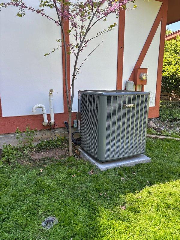 Completed full residential air conditioning system installation including outdoor condenser unit and indoor air handler. Outdoor unit was positioned on concrete pad in side yard with proper clearances maintained, PVC condensate drainage lines installed and secured to building exterior. Indoor equipment installed in basement mechanical area with new flexible ductwork connections, PVC piping for drainage and venting, and all electrical connections completed per manufacturer specifications. System tested and verified operational upon completion.