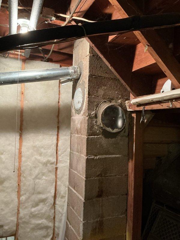 Completed repair of basement chimney duct system. The metal vent pipe penetration through the concrete block wall was serviced, addressing accumulated soot and deterioration issues. All work performed according to quoted specifications with photo documentation provided.